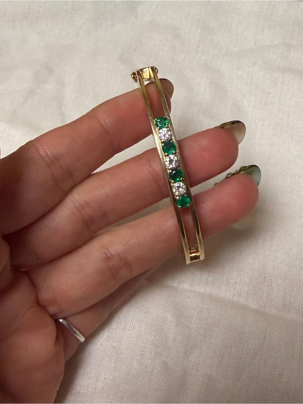 14k gold Bracelet with emeralds and diamonds on it.